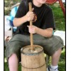 Boy is Using an Old Fashion Wooden Churn to Make Butter The antique wooden churn with stirring stick is used to beat cream in order to separate the butter fat.