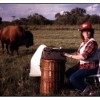 Publicity photo of Janice VanCleave typing in a field with a Buffallo nearby.