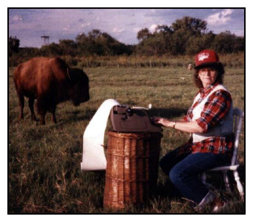 Publicity photo of Janice VanCleave typing in a field with a Buffallo nearby.